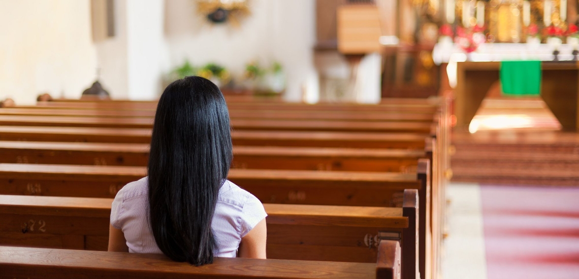 Frau sitzt in Kirche