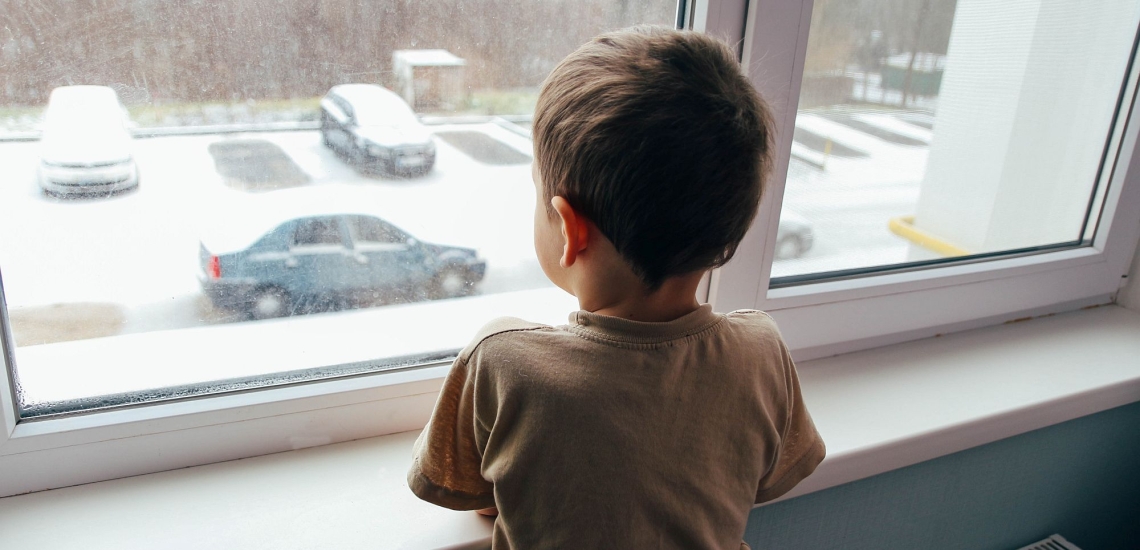 Junge sieht aus dem Fenster 