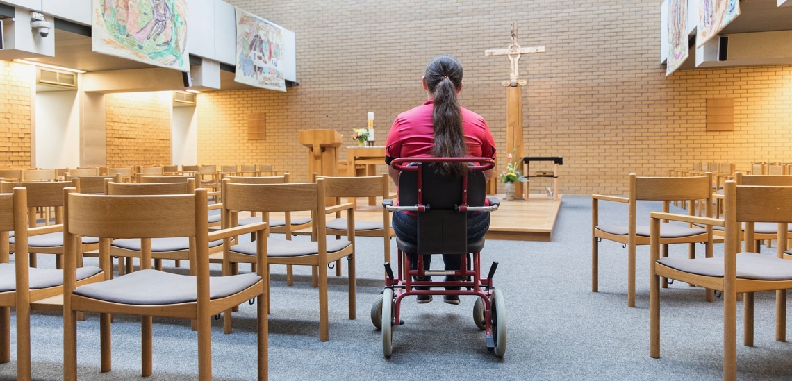 Frau im Rollstuhl in der Klinikkirche des Klinikums der Universität Großhadern in München 