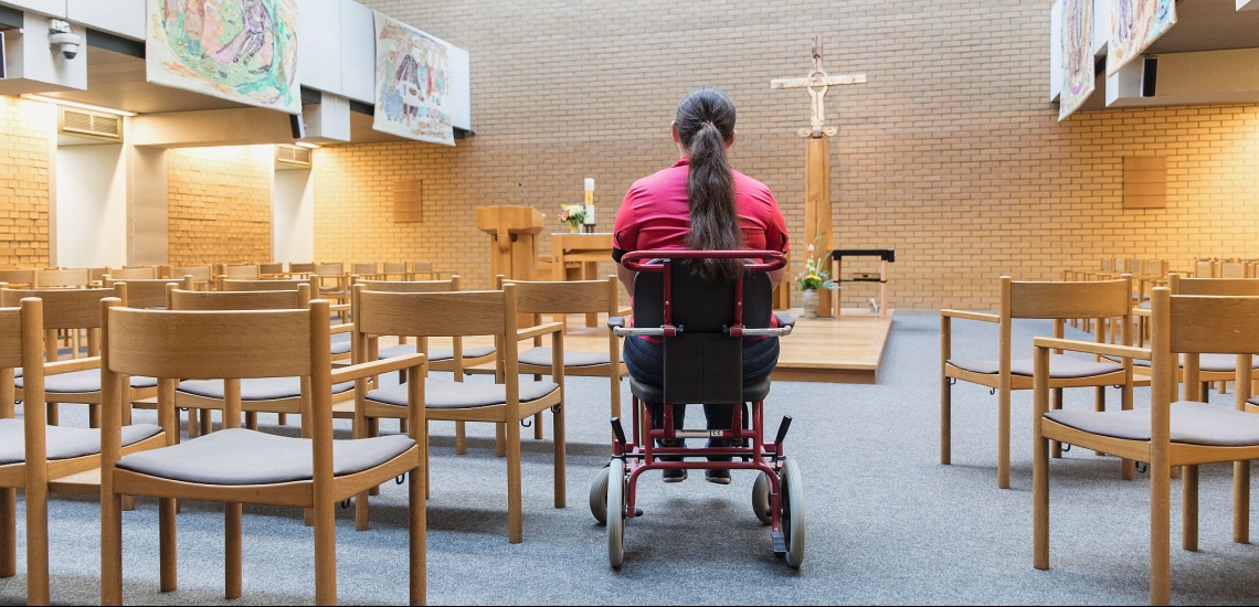 Frau im Rollstuhl in der Klinikkirche des Klinikums der Universität Großhadern in München 