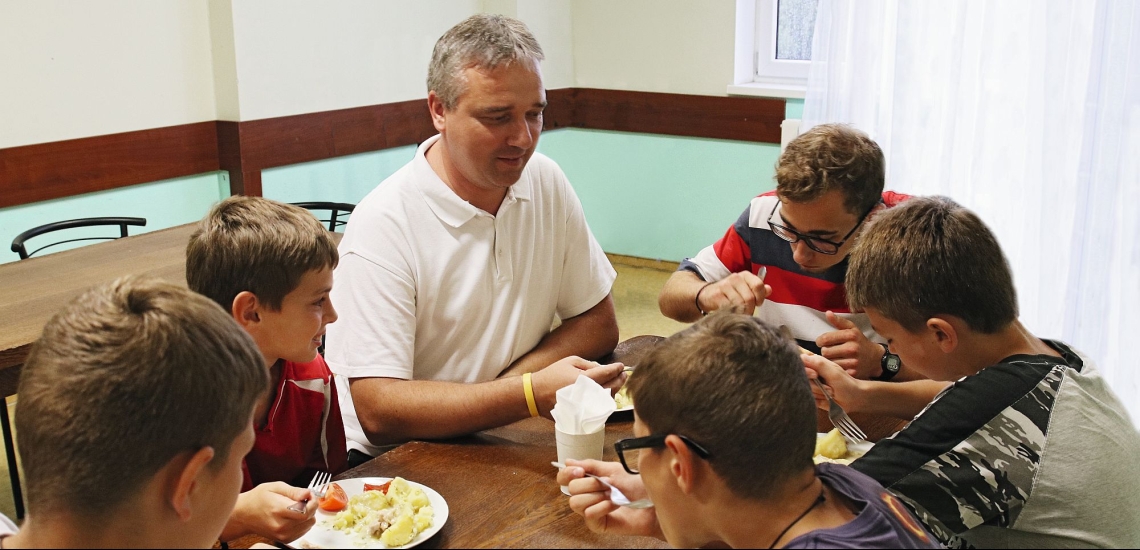 Gruppe mit Betreuer beim Essen im Kinderheim der Salesianer in Lemberg