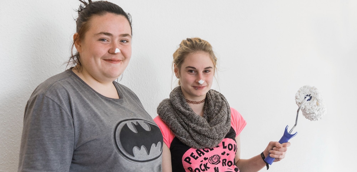 Zwei junge Frauen lachend mit Wandfarben 