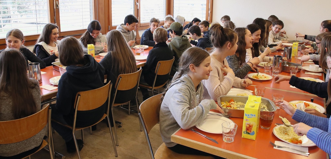Jugendliche essen in Speisesaal 