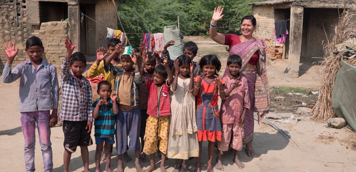 Kinder einer Schule für Musahar mit ihrer Lehrerin auf Dorfplatz in Indien 