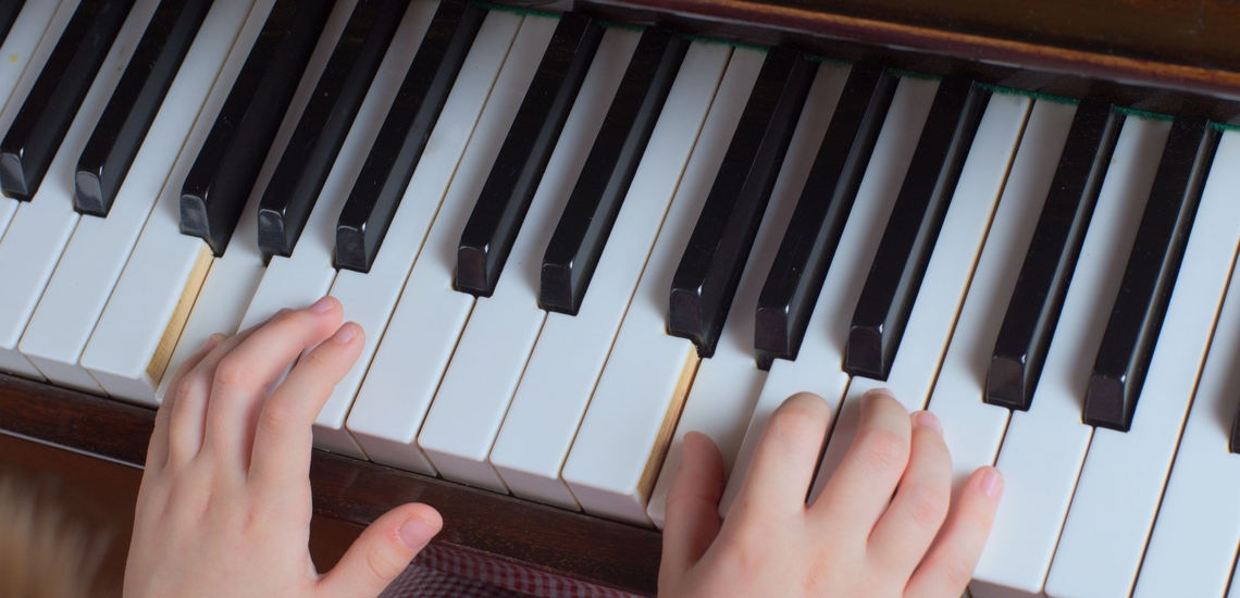 Kinderhände auf Klavier 