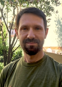 Mann mit grünem T-Shirt und Bart im Garten