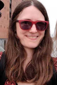 Porträt einer Frau mit roter Sonnenbrille und langen brünetten Haaren