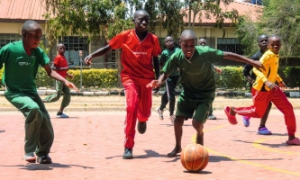 Kinder spielen Fußball auf Sportplatz im Don Bosco Zentrum in Nairobi