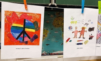Kunstwerke von Kindern und Jugendlichen zum Thema Frieden hängen an einer Wäscheleine