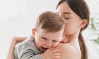 Baby weint auf Arm der Mutter