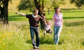 Vater, Mutter und Kind beim Spaziergang im Grünen