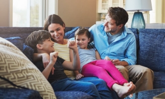 Eltern und Kinder unterhalten sich angeregt auf Sofa