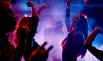 Junge Menschen tanzen ausgelassen in Club