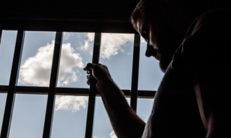 Inhaftierter am vergitterten Fenster