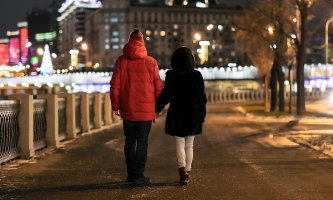 Ehepaar spaziert am Abend Hand in Hand durch eine Stadt