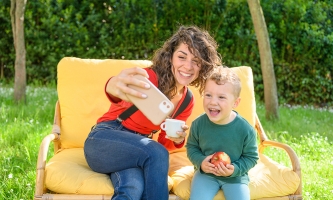 Eine Mutter macht im Garten ein Selfie mit ihrem Sohn.