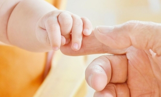 Babyhand hält Erwachsenenhand