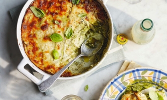 Vegetarische Lasagne in Auflaufform mit Löffel und Getränkefläschchen