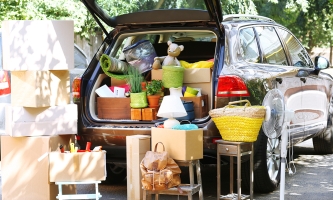 Kombi mit offener Heckklappe, im Kofferraum und drumherum Kartons, Taschen, Lampen use.