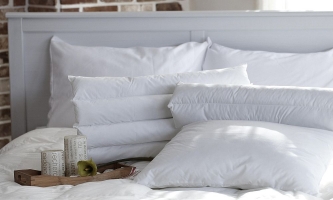 Doppelbett mit weißer Bettwäsche und Deko