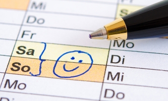 Kalender, in dem ein Samstag und Sonntag mit einem Smiley markiert sind, Kugelschreiber
