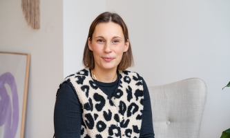 Eine Frau Anfang 30 mit schulterlangem braunem Haar blickt freundlich in die Kamera.