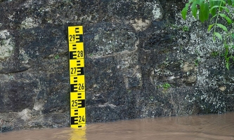 Ein an eine Steinmauer angebrachter Pegel zeigt den Wasserstand an