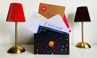 Kiste mit Briefen, daneben zwei Stehlampen