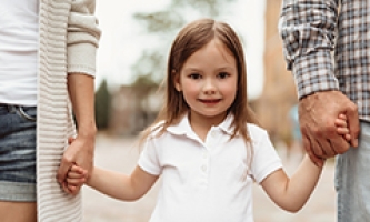 Mädchen an den Händen von Mama und Papa