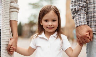Mädchen an den Händen von Mama und Papa