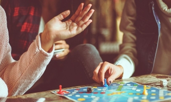 Hände gestikulieren und würfeln auf Brettspiel