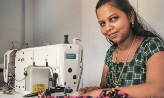 Schneiderin Monisha bei der Arbeit an der Nähmaschine