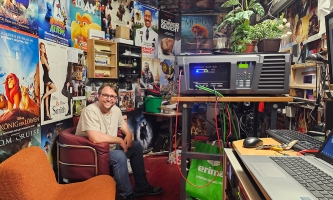 Roman Sorger im Schnittraum umgeben von vielen Filmplakaten