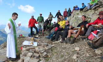 Pater Peter Rinderer predigt vor Wanderern und Bergsteigern auf dem Berg