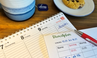Kalender, Dienstplan, Tee und Keks auf einem Tisch