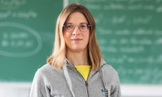 Lehrerin vor Tafel in Klassenzimmer 