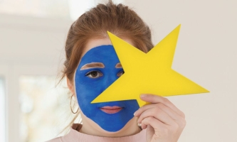 Porträt junge Frau mit blauer Schminke und gelbem Stern 