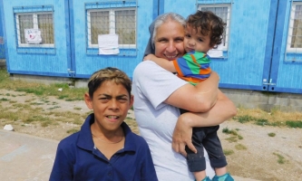 Sschwester mit zwei Kindern vor Container