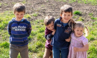 vier Kinder auf Rasen 
