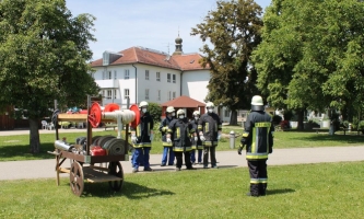 Feuerwehrleute haben sich auf Wiese aufgestellt 