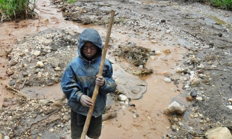 Junge mit Stock in Mine im Kongo 