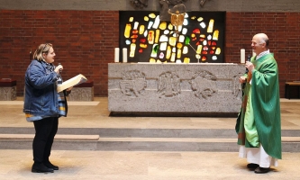 Frau und Priester im Altarraum einer Kirche 