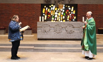 Frau und Priester im Altarraum einer Kirche 