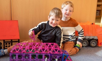 zwei Kinder mit Bauklötzen im Kindergarten