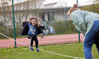 ein Mädchen hüpft über ein langes Springseil