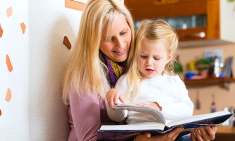 Mutter und Kind lesen zuhause in Buch 