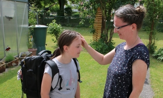 Stephanie Altmann zeichnet ihrer Tochter ein Kreuzzeichen auf die Stirn.