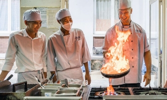 Kochschüler und Ausbilder am Herd in der Gastronomieschule von Don Bosco in Ho Chi Minh City