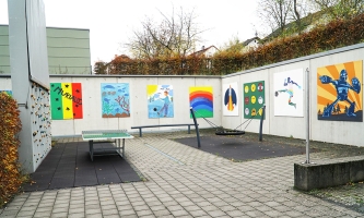 Innenhof mit Spielgeräten wie Tischtennisplatte, Schaukel und Kletterwand