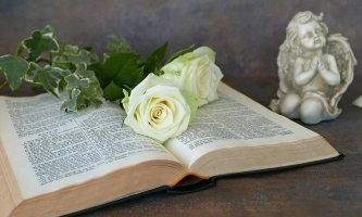 Aufgeschlagene Bibel mit Blumen und Engel 